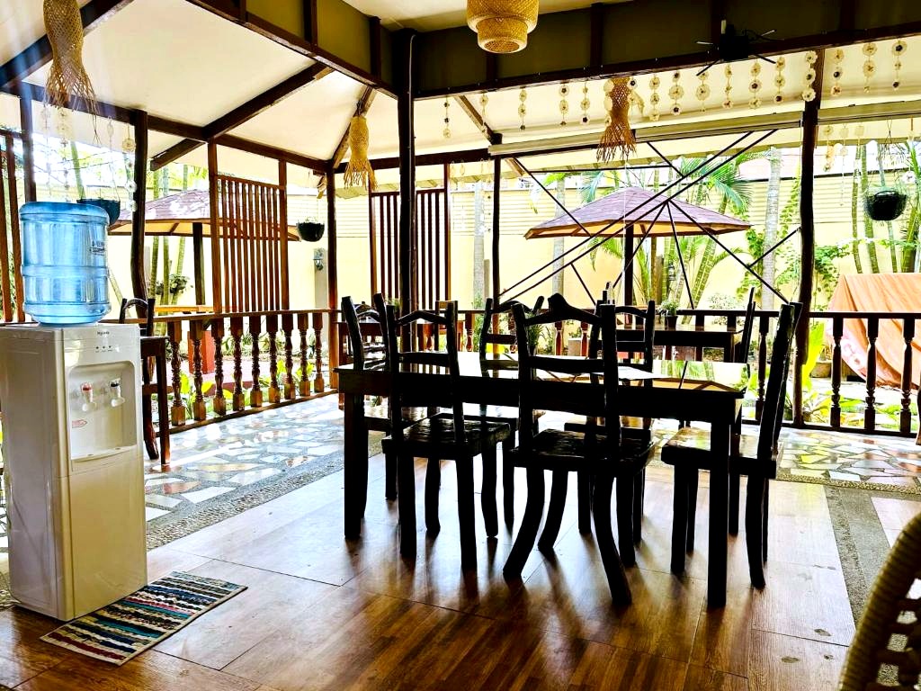 The family dining area at La Petite Pension, wooden floor and open air